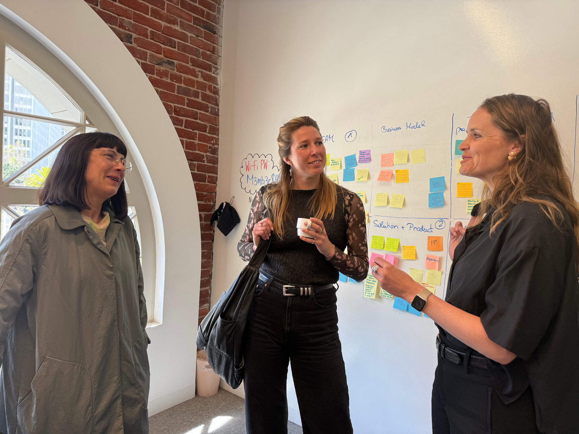 Participants discussing ideas in front of a strategy wall during a GUILD session